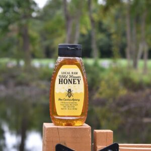 Local raw wildflower honey bottle outdoors